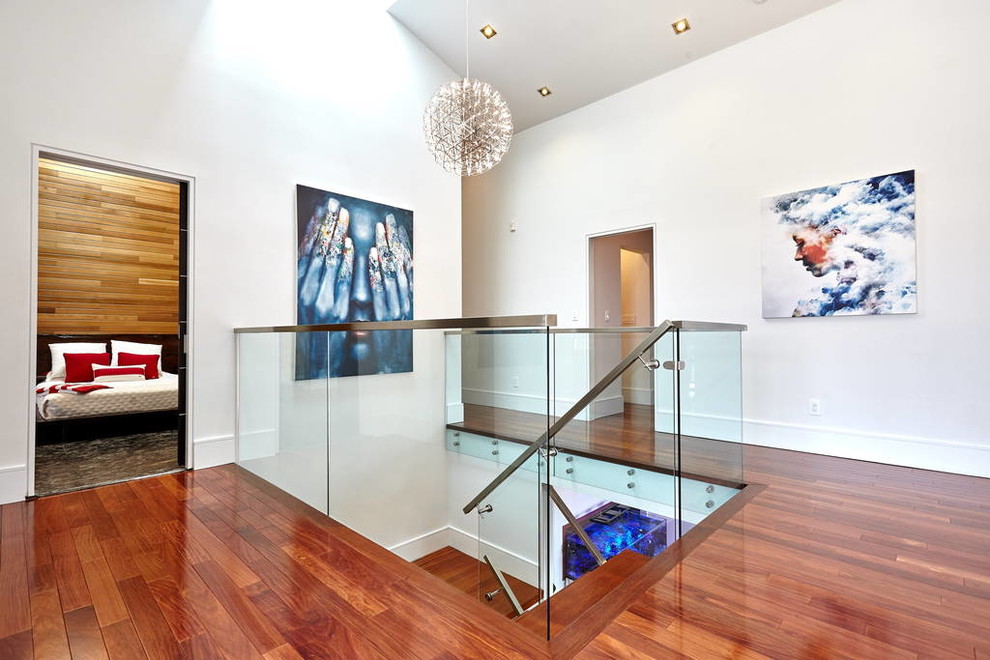 This is an example of a mid-sized modern hallway in Toronto with white walls and medium hardwood floors.