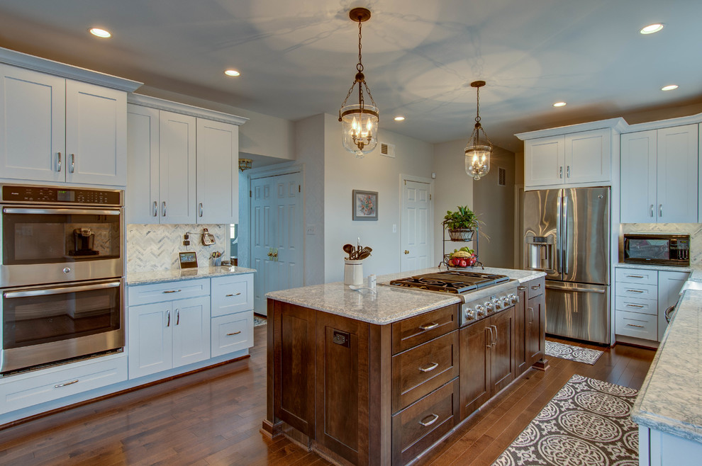Mid-sized transitional u-shaped dark wood floor and brown floor eat-in kitchen photo in DC Metro with a farmhouse sink, shaker cabinets, white cabinets, stainless steel appliances, an island, gray countertops, quartzite countertops, white backsplash and mosaic tile backsplash