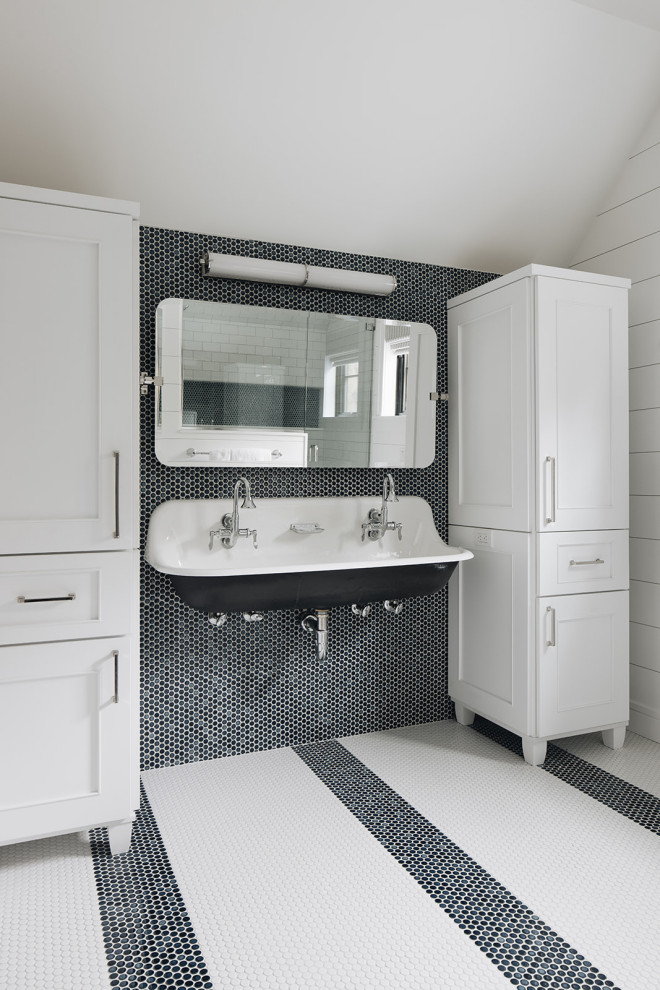 Bathroom - Bright bathroom featuring a trough sink, chrome faucets, navy penny tile backsplash, striped penny tile flooring, white cabinetry, and shiplap walls.