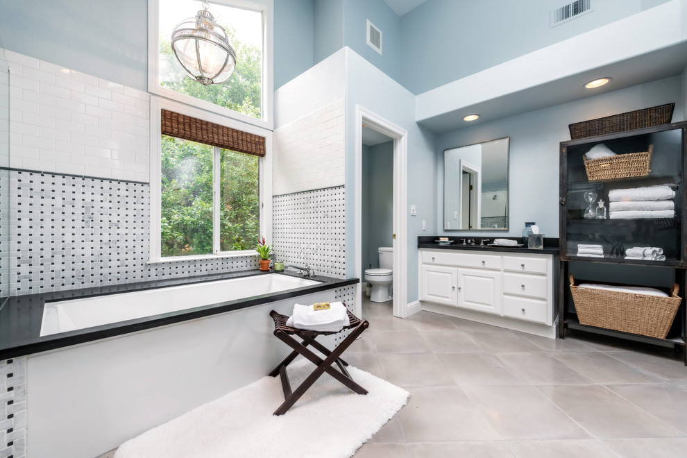 Traditional bathroom in San Francisco with raised-panel cabinets, white cabinets, an undermount tub, multi-coloured tile and an enclosed toilet.