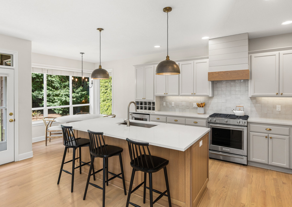 Open concept kitchen - transitional l-shaped light wood floor open concept kitchen idea in Portland with an undermount sink, gray cabinets, quartz countertops, terra-cotta backsplash and an island