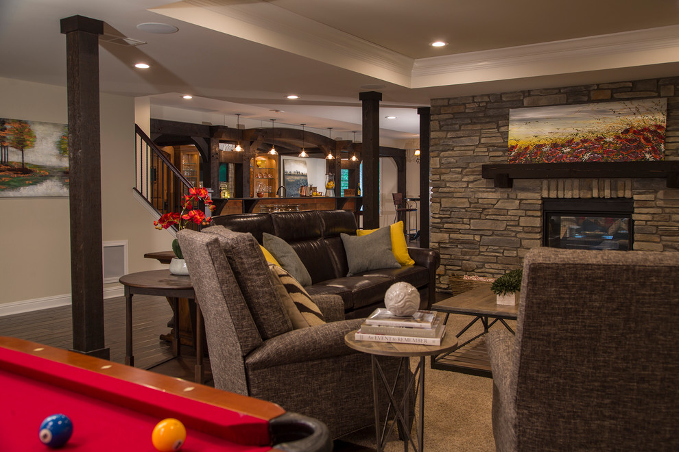 This is an example of a large country walk-out basement in Detroit with grey walls, dark hardwood floors, a two-sided fireplace and a stone fireplace surround.