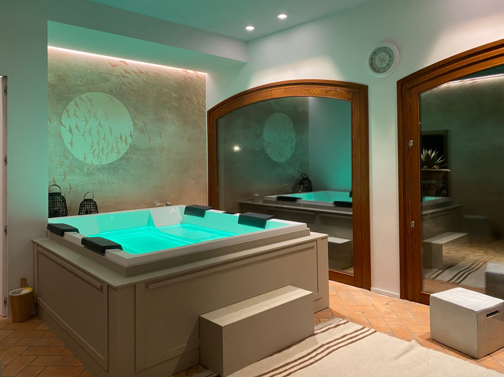 他の地域にあるラグジュアリーな広いラスティックスタイルのおしゃれな浴室 (大型浴槽、ベージュの壁、レンガの床、オレンジの床、照明、壁紙、白い天井) の写真