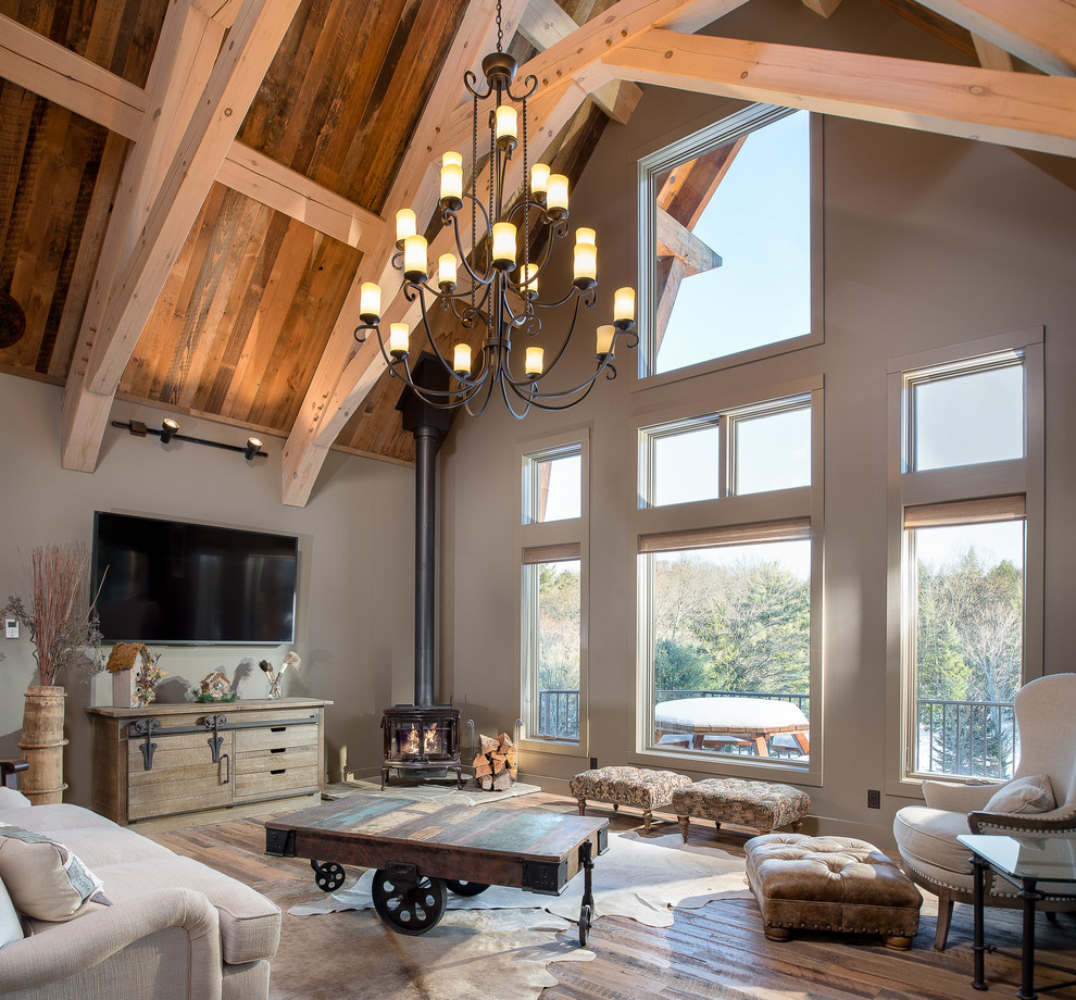 This is an example of a country loft-style living room in Atlanta with grey walls, medium hardwood floors and a wood stove.