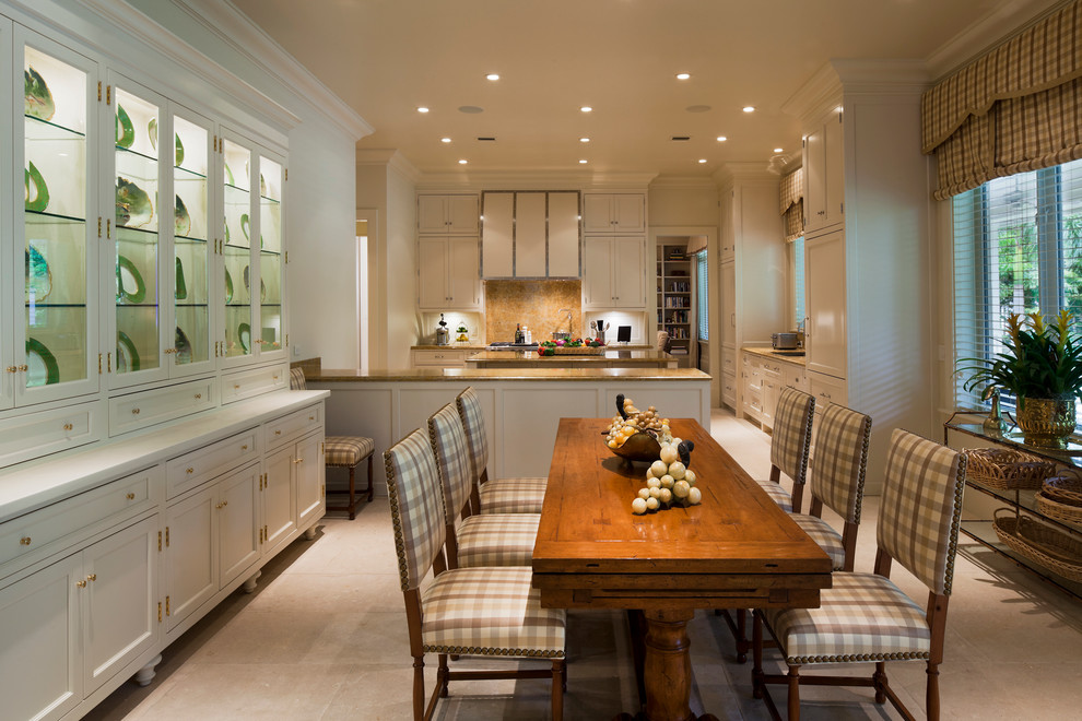 This is an example of a large traditional galley eat-in kitchen in Miami with recessed-panel cabinets, white cabinets, brown splashback, stone slab splashback, panelled appliances, travertine floors, beige floor, an undermount sink, granite benchtops, multiple islands and brown benchtop.