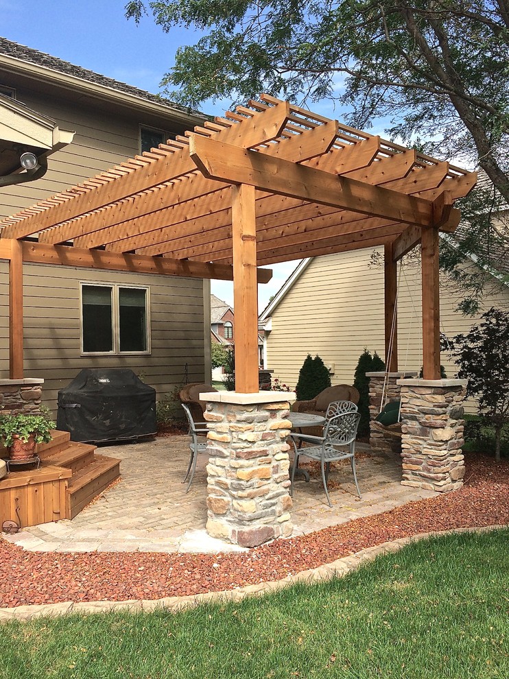 Patio container garden - mid-sized traditional backyard stone patio container garden idea with a pergola