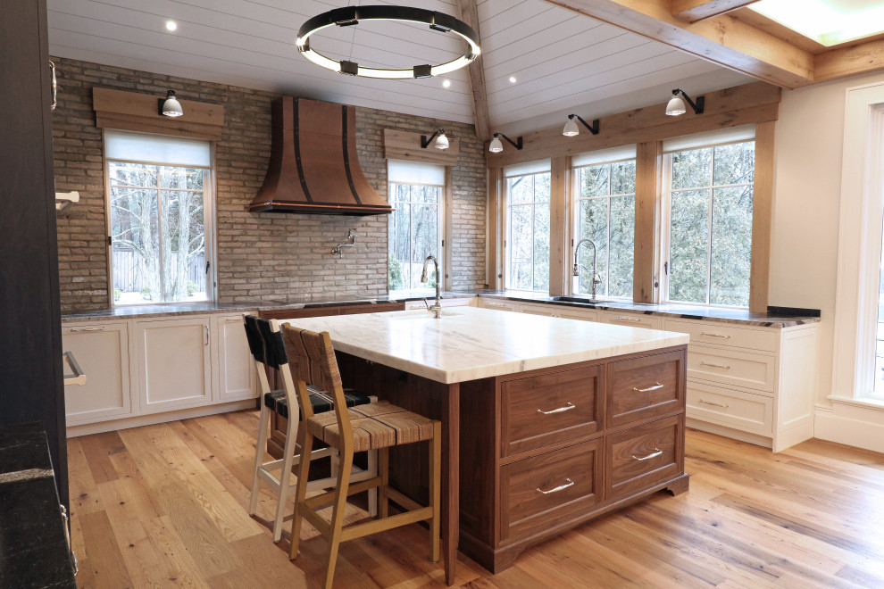 Expansive transitional u-shaped eat-in kitchen in Boston with a farmhouse sink, beaded inset cabinets, marble benchtops, multi-coloured splashback, brick splashback, stainless steel appliances, medium hardwood floors, with island, multi-coloured floor and multi-coloured benchtop.