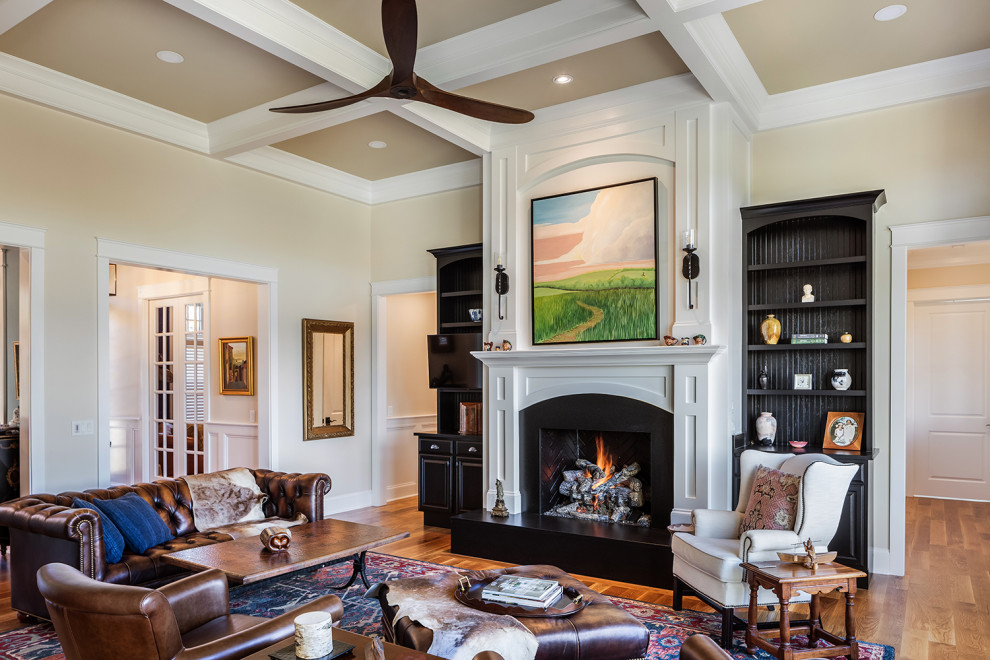 Design ideas for a mid-sized formal open concept living room in Other with beige walls, light hardwood floors, a standard fireplace, a wood fireplace surround, a wall-mounted tv and coffered.