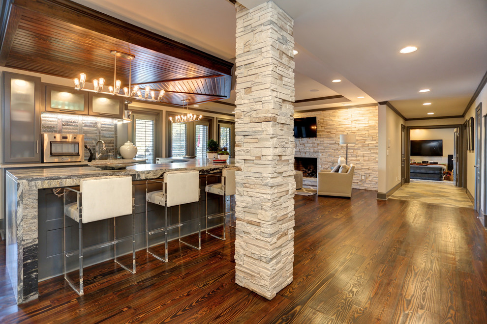 This is an example of a large transitional walk-out basement in Atlanta with grey walls, slate floors, a standard fireplace, a stone fireplace surround and multi-coloured floor.