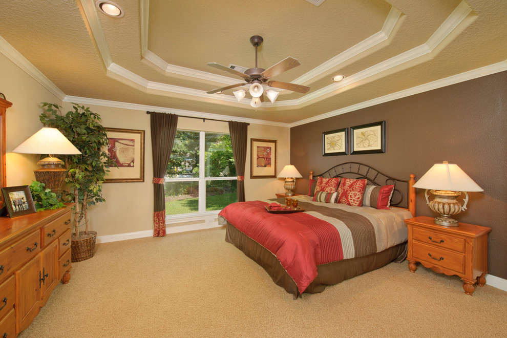 Inspiration for a large traditional master bedroom in Houston with beige walls, carpet, no fireplace and beige floor.