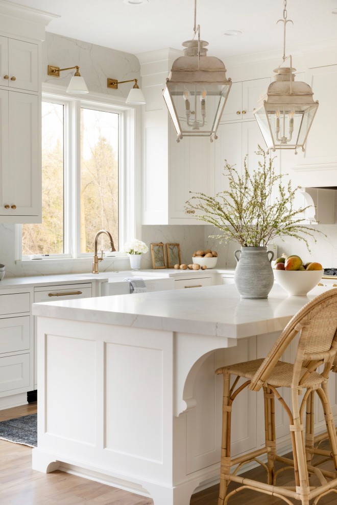 Exempel på ett stort klassiskt vit vitt kök, med en rustik diskho, luckor med profilerade fronter, vita skåp, bänkskiva i kvartsit, vitt stänkskydd, integrerade vitvaror, ljust trägolv, en köksö och brunt golv