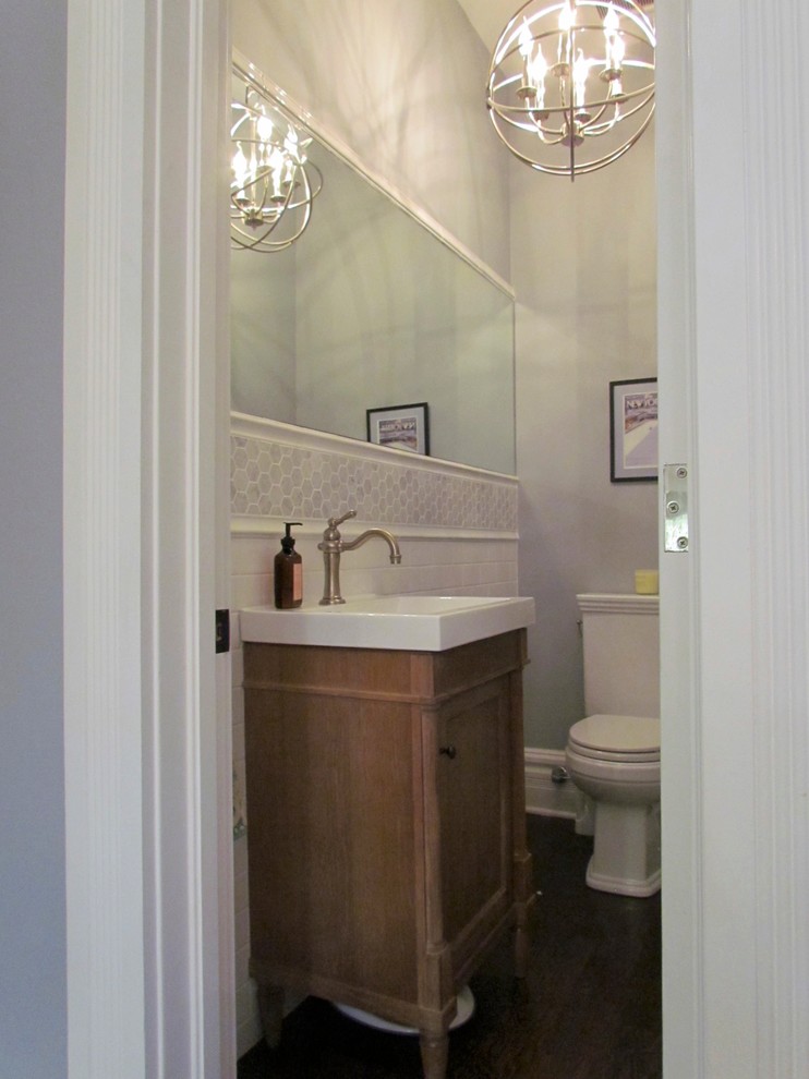 This is an example of a small traditional powder room in Chicago with furniture-like cabinets, white tile, ceramic tile, grey walls and dark wood cabinets.