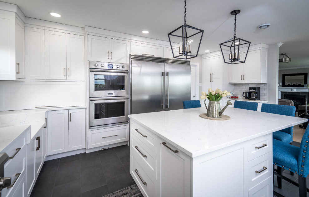 Mid-sized transitional l-shaped ceramic tile and gray floor eat-in kitchen photo with an undermount sink, white cabinets, quartz countertops, white backsplash, ceramic backsplash, stainless steel appliances, an island and white countertops