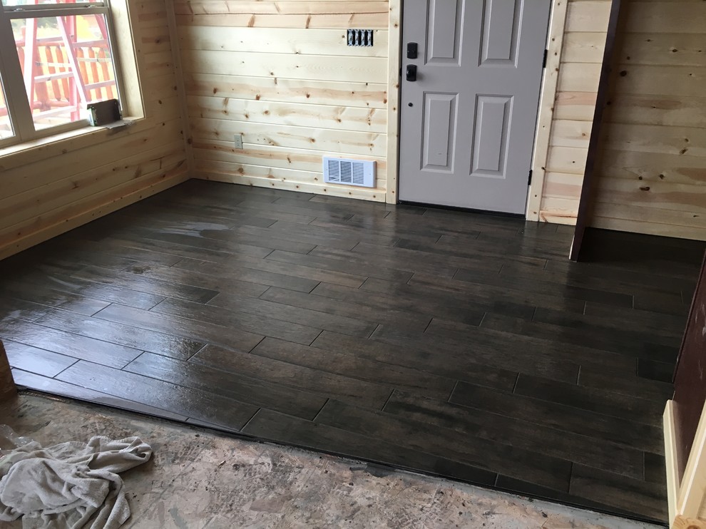 Example of a large mountain style l-shaped porcelain tile eat-in kitchen design with flat-panel cabinets, dark wood cabinets and an island