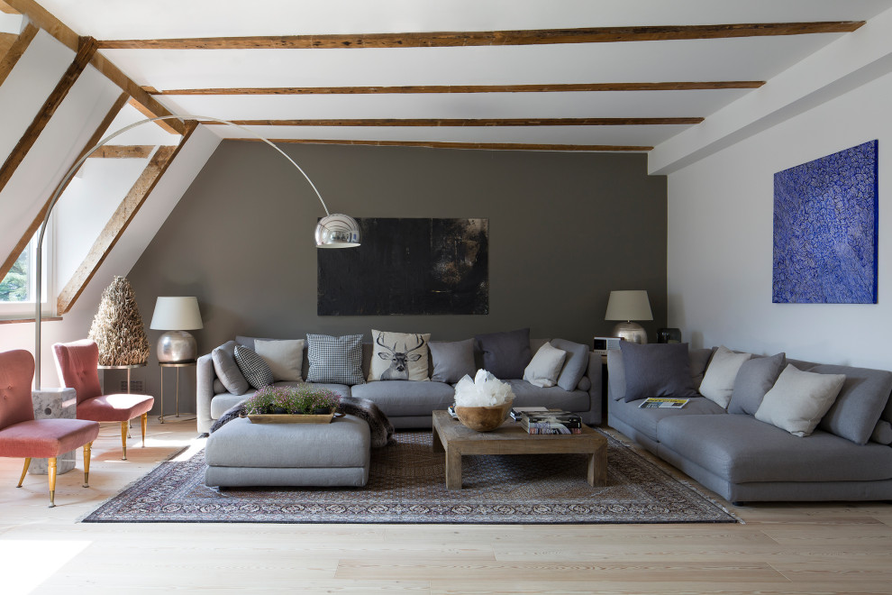 Foto di un ampio soggiorno minimal con pareti grigie, parquet chiaro e travi a vista