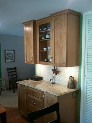 Mid-sized transitional u-shaped medium tone wood floor eat-in kitchen photo in Cincinnati with an undermount sink, flat-panel cabinets, medium tone wood cabinets, quartz countertops, multicolored backsplash, mosaic tile backsplash, stainless steel appliances and an island