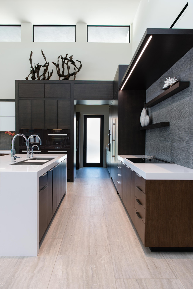 Photo of an expansive contemporary l-shaped kitchen in Las Vegas with an undermount sink, flat-panel cabinets, dark wood cabinets, grey splashback, porcelain floors, with island, beige floor and white benchtop.