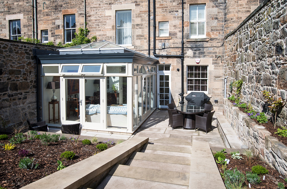 Large traditional sunroom in Edinburgh with travertine floors and a skylight.