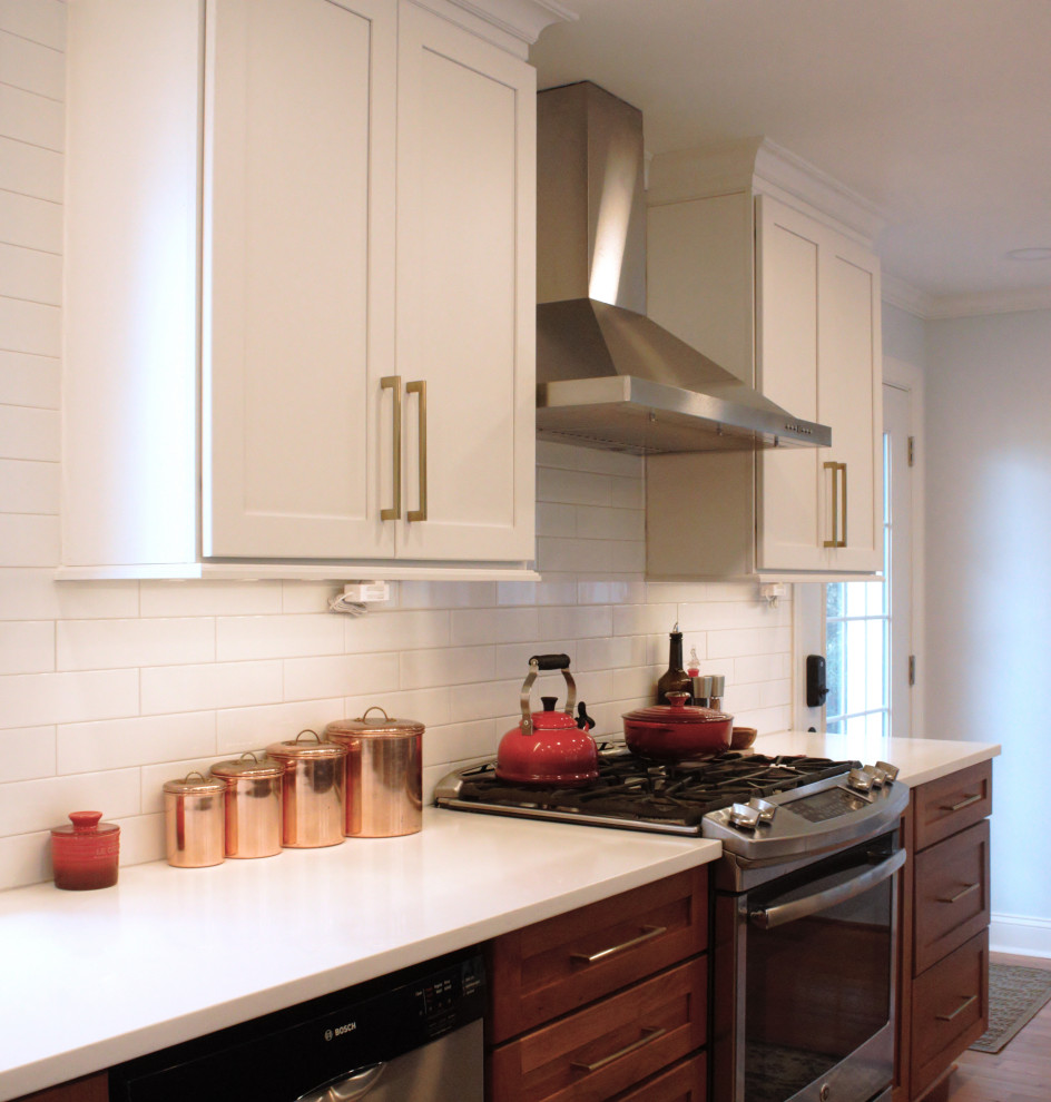 Inspiration for a mid-sized transitional l-shaped eat-in kitchen in Philadelphia with an undermount sink, shaker cabinets, blue cabinets, quartz benchtops, white splashback, subway tile splashback, stainless steel appliances, medium hardwood floors, with island, brown floor and white benchtop.