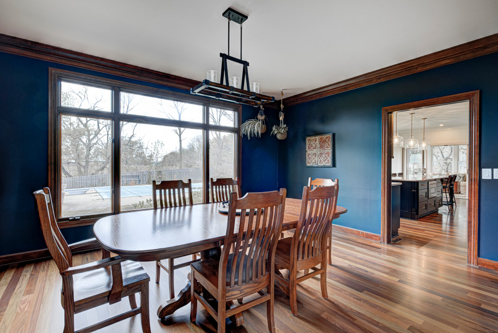 Cette image montre une salle à manger design fermée et de taille moyenne avec un mur bleu, un sol en bois brun, aucune cheminée et un sol beige.