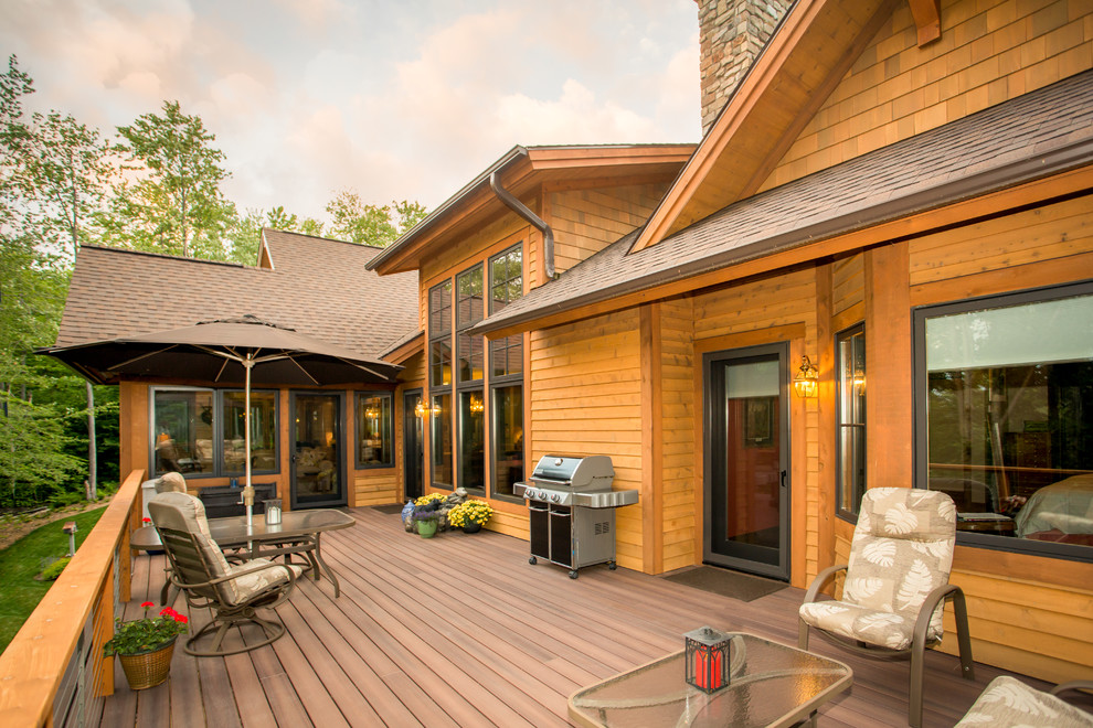 Large mountain style backyard deck photo with no cover