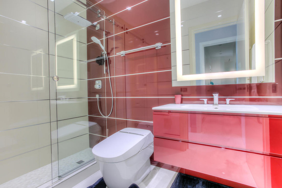 This is an example of a mid-sized contemporary 3/4 bathroom in Miami with flat-panel cabinets, red cabinets, an alcove shower, a one-piece toilet, red tile, porcelain tile, red walls, porcelain floors, an integrated sink and solid surface benchtops.