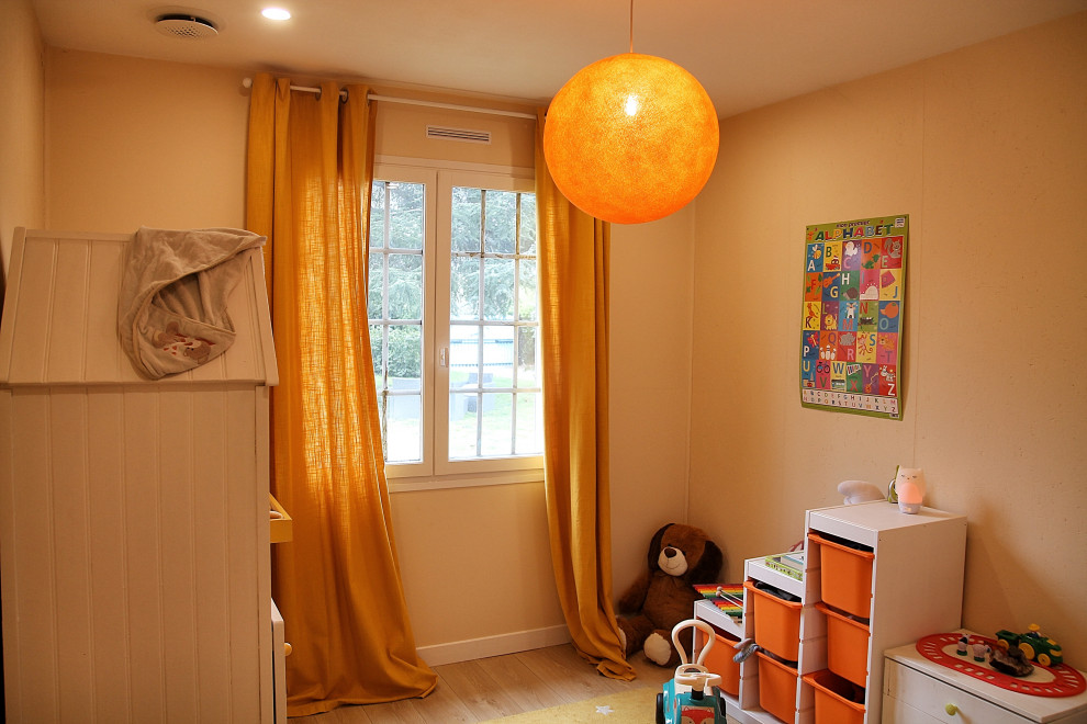 This is an example of a medium sized classic gender neutral nursery in Other with yellow walls, laminate floors, yellow floors and wood walls.