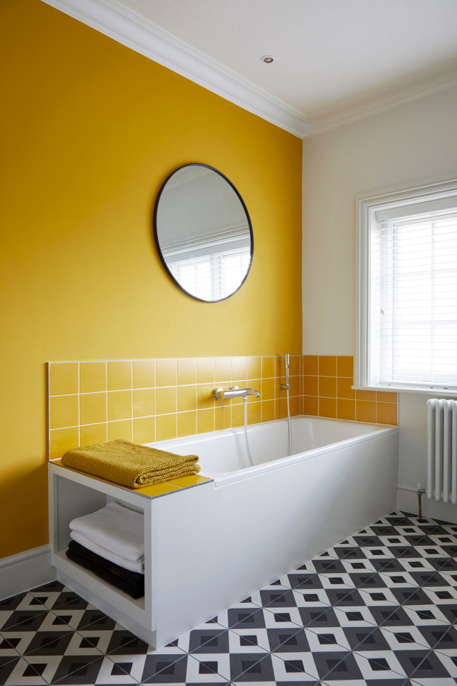 Inspiration for a contemporary bathroom in Surrey with a corner tub, yellow tile, yellow walls and multi-coloured floor.