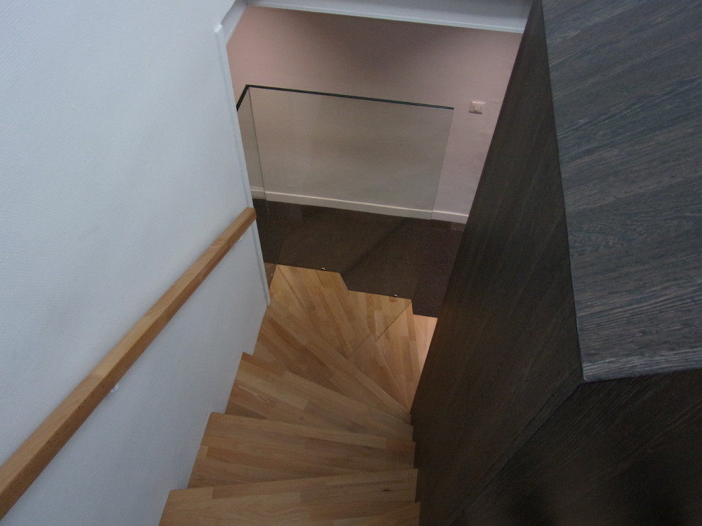 Design ideas for a mid-sized contemporary wood curved staircase in Marseille with wood risers and glass railing.