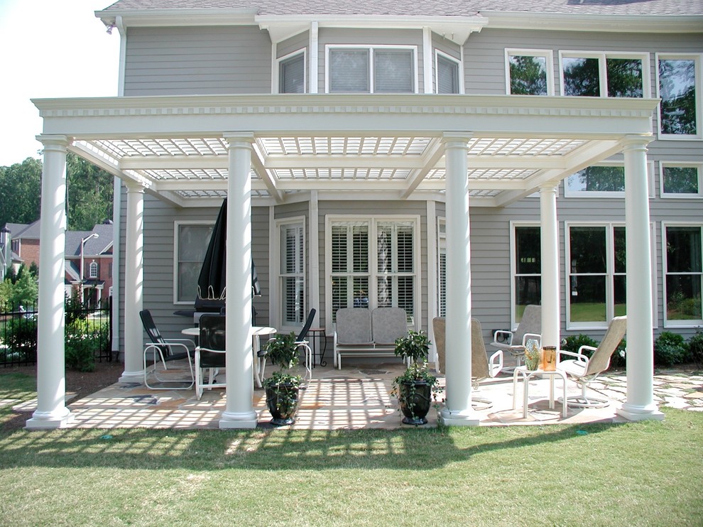 This is an example of a mid-sized traditional backyard patio in Atlanta with natural stone pavers and a pergola.