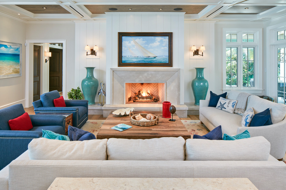 Photo of a large beach style enclosed living room in Denver with white walls, light hardwood floors, a standard fireplace, brown floor, a concrete fireplace surround and no tv.