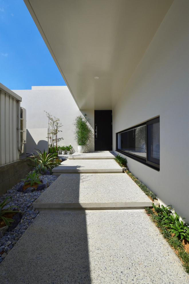 Inspiration for a modern verandah in Other with concrete pavers and a roof extension.