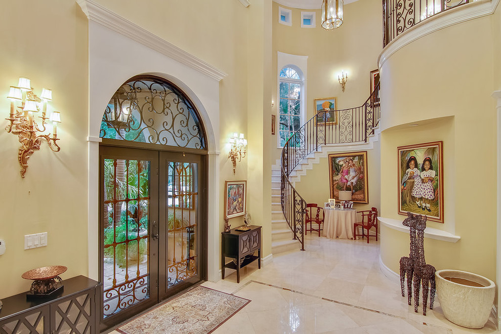 Inspiration for a traditional foyer in Miami with yellow walls, a double front door and a glass front door.