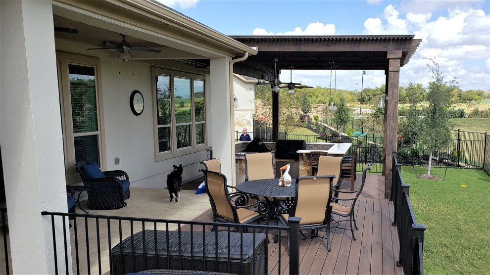 This is an example of a large eclectic back metal railing terrace in Austin with an outdoor kitchen and a pergola.