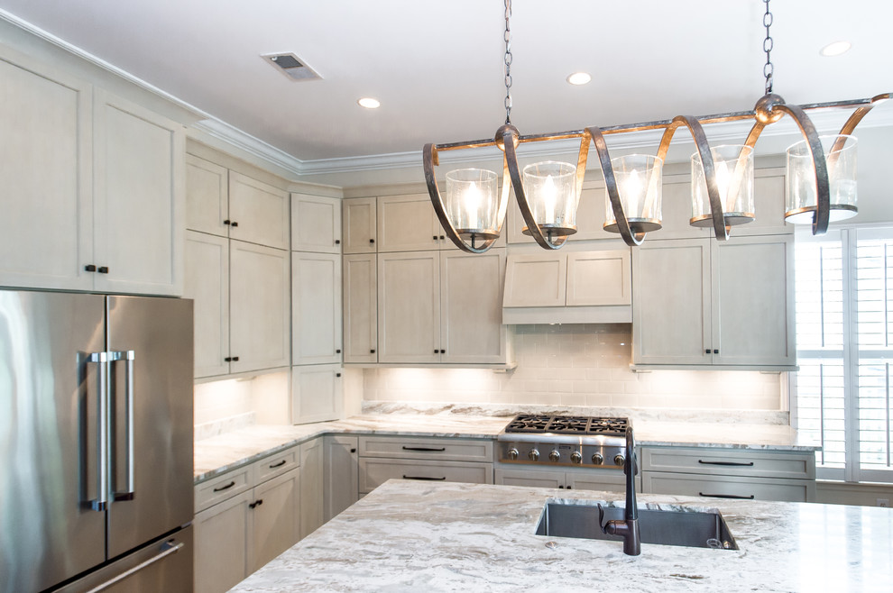 Photo of a transitional l-shaped open plan kitchen in Charleston with a single-bowl sink, shaker cabinets, beige cabinets, granite benchtops, beige splashback, subway tile splashback, stainless steel appliances, porcelain floors and with island.