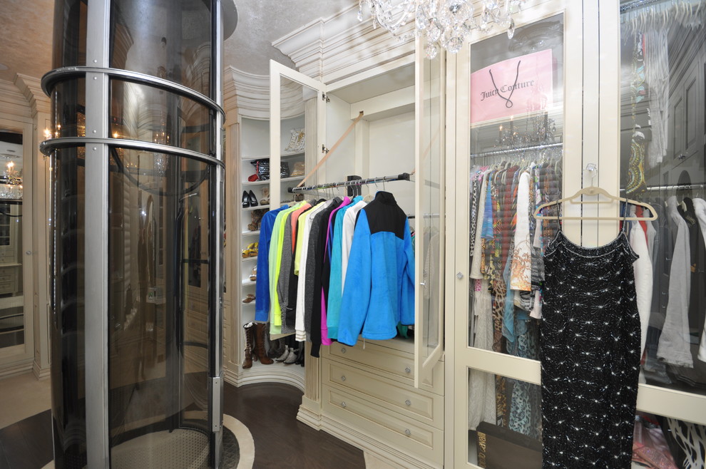 Walk-in closet - large traditional women's dark wood floor walk-in closet idea in New York with beaded inset cabinets and white cabinets