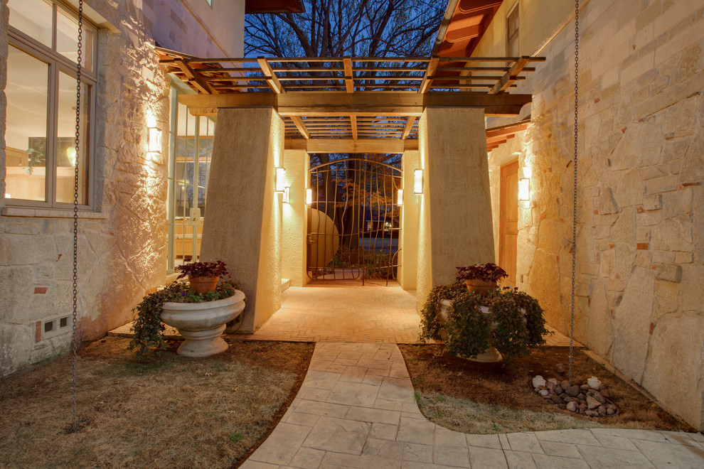 Photo of a large contemporary two-storey beige exterior in Dallas with stone veneer.
