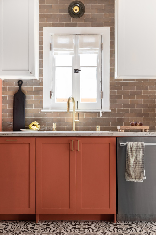 This is an example of a mediterranean kitchen in Other with orange cabinets, cement tiles and no island.