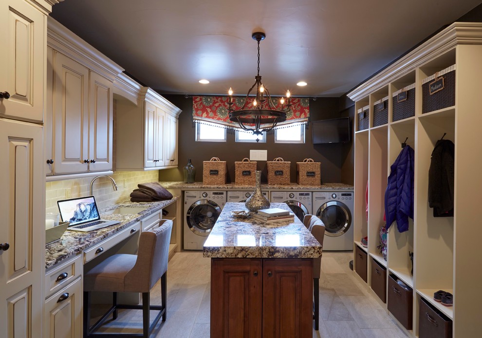 Photo of a large traditional dedicated laundry room in Denver with an undermount sink, raised-panel cabinets, distressed cabinets, porcelain floors and a side-by-side washer and dryer.