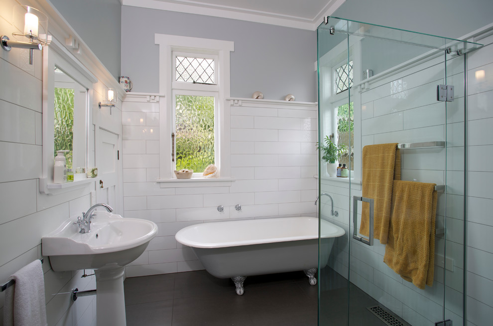 Photo of a mid-sized country 3/4 bathroom in Auckland with a claw-foot tub, a corner shower, white tile, subway tile, grey walls and a pedestal sink.