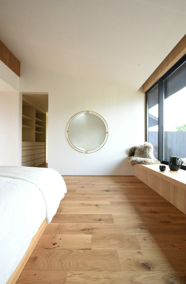 Foto de dormitorio principal grande con paredes multicolor y suelo de madera clara