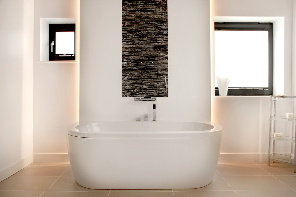 Photo of a mid-sized contemporary kids bathroom in Oxfordshire with a freestanding tub, white tile, ceramic tile, white walls and porcelain floors.