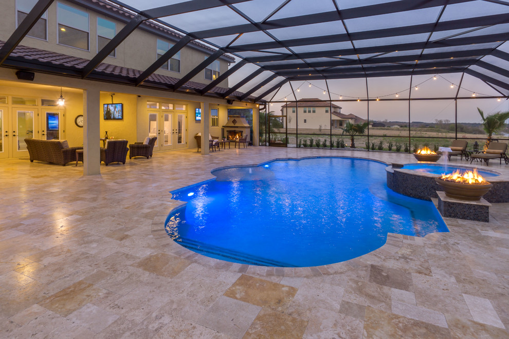 Inspiration for an expansive mediterranean indoor custom-shaped pool in Orlando with a hot tub and natural stone pavers.