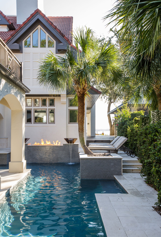 This is an example of an expansive mediterranean courtyard rectangular pool in Jacksonville with with a pool and natural stone pavers.