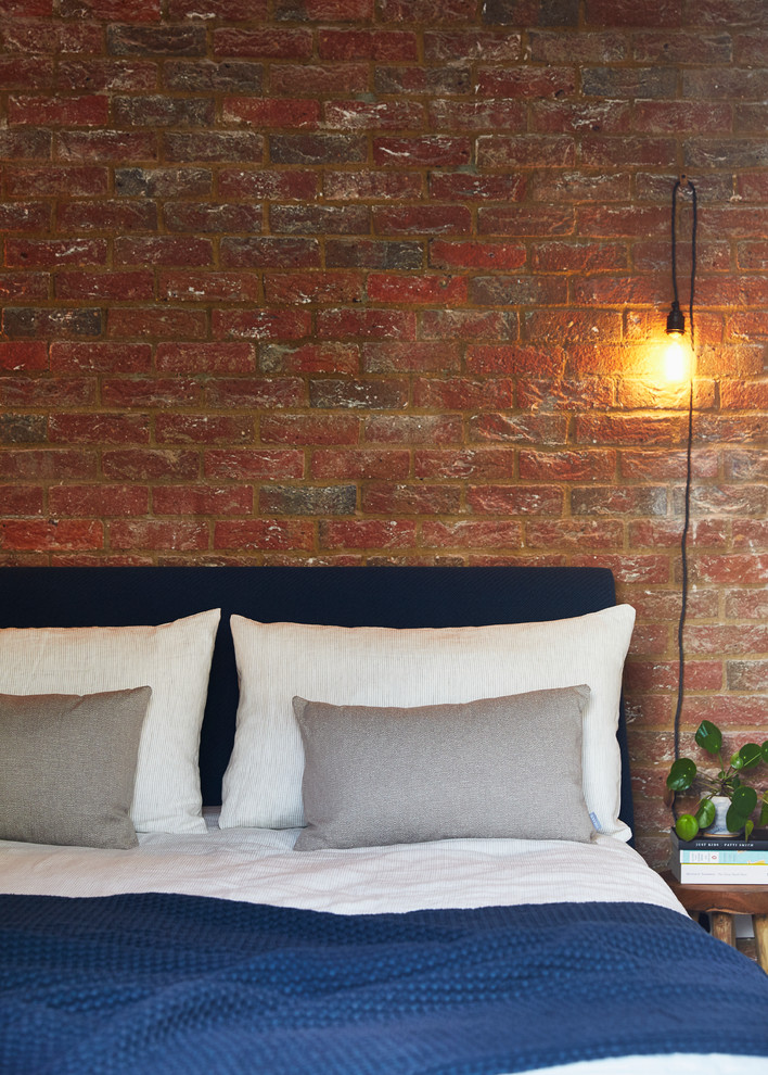 Design ideas for a contemporary guest bedroom in London with brick walls.