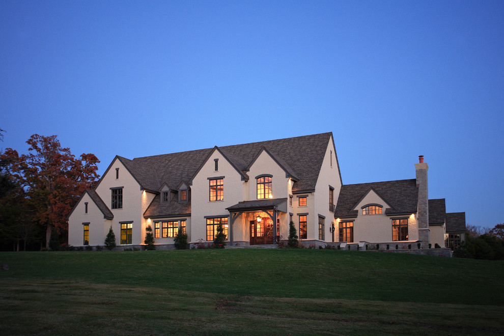 This is an example of an expansive traditional two-storey stucco beige exterior in Little Rock with a gable roof.