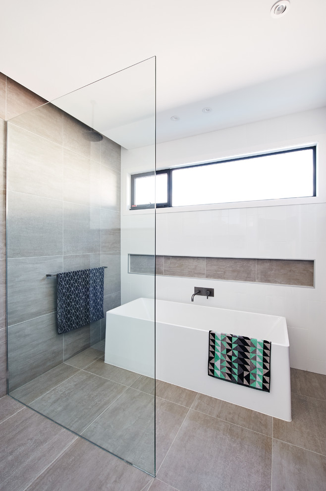 Inspiration for a large contemporary master bathroom in Melbourne with flat-panel cabinets, light wood cabinets, a shower/bathtub combo, white tile, glass sheet wall, grey walls, ceramic floors, a drop-in sink, engineered quartz benchtops, grey floor, an open shower and white benchtops.