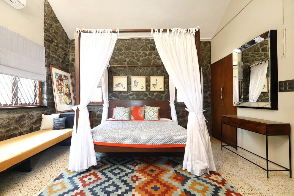 Photo of a transitional master bedroom in Mumbai with beige walls, concrete floors and beige floor.
