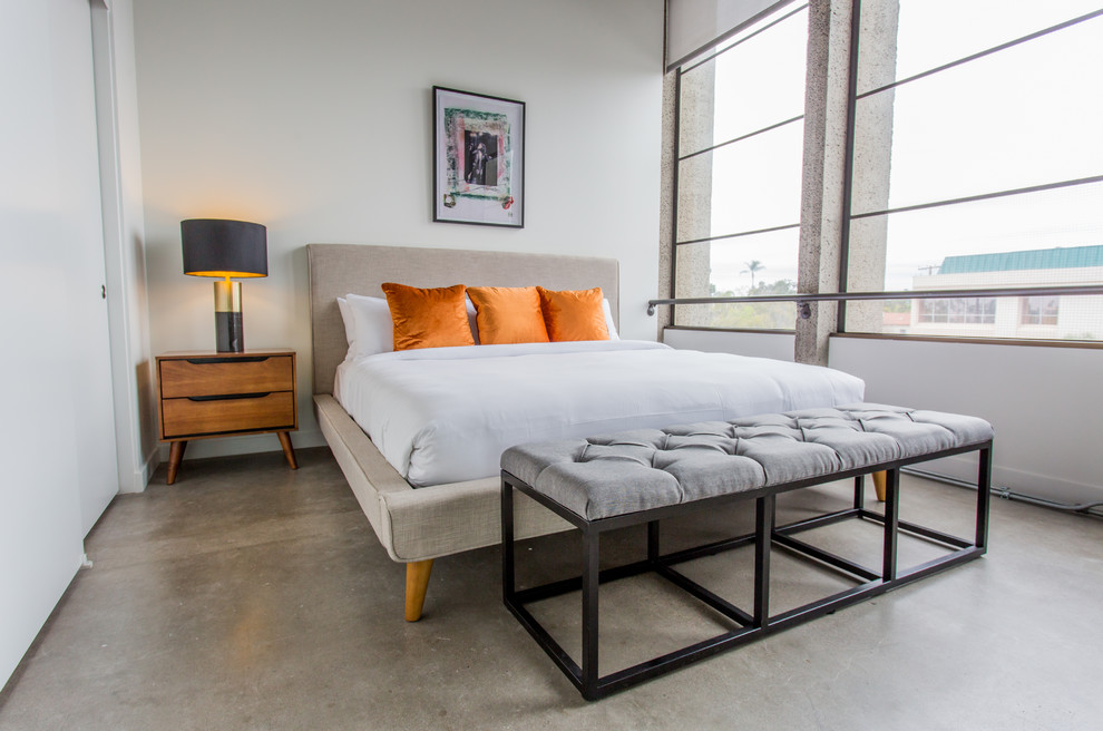 Small midcentury loft-style bedroom in San Diego with grey walls, concrete floors and no fireplace.