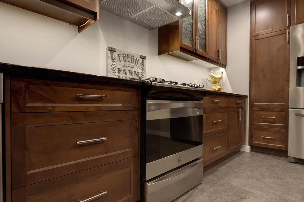 Mid-sized transitional kitchen photo with shaker cabinets, medium tone wood cabinets, quartz countertops, stainless steel appliances and an island